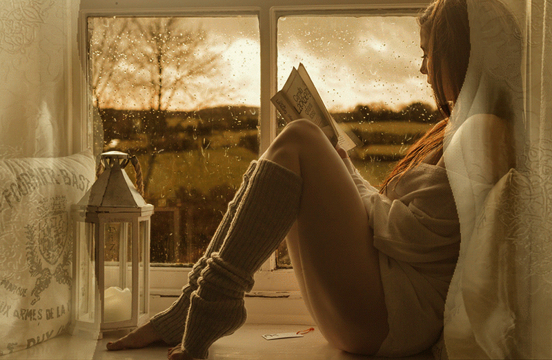 Девушка сидит возле окна